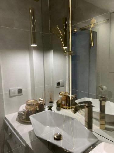 a bathroom with a sink and a mirror at M&S Lux Apartments - cisza, balkon, 5 min od Manufaktury in Łódź