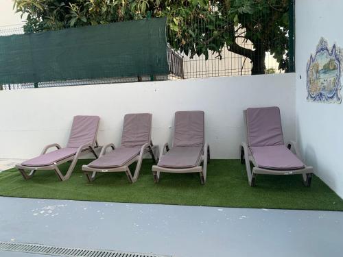 a group of three chairs sitting on the grass at Recanto da Paz in Pombal