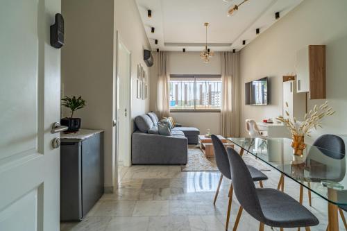 a kitchen and living room with a glass table and chairs at AeroSuite in Nouaceur