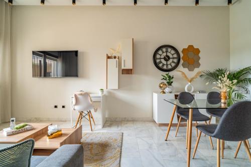 a living room with a table and a clock on the wall at AeroSuite in Nouaceur