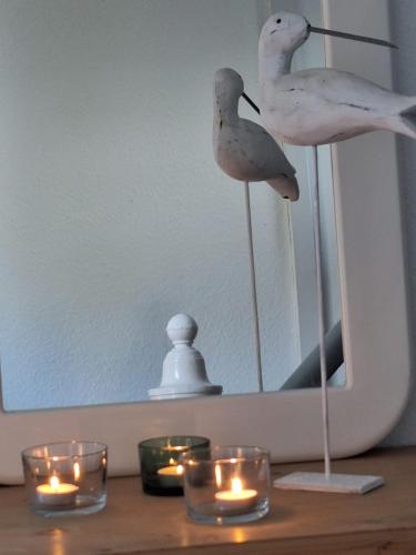 two birds on a table with candles and a mirror at Alter Mühlenhof in Nordenham