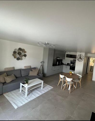 un salon avec un canapé et une table dans l'établissement Appartement calme, à Montfermeil