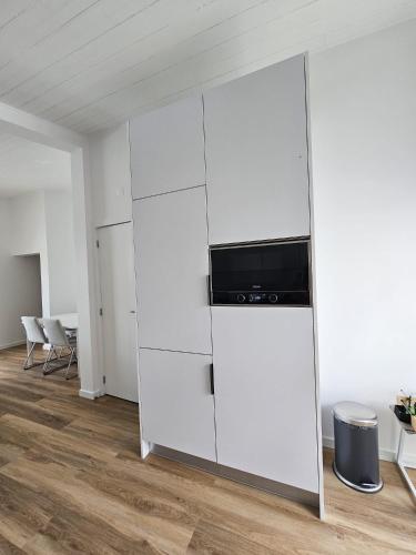 a large white cabinet with a television on top of it at Sunflower Castle View in Óbidos in Óbidos