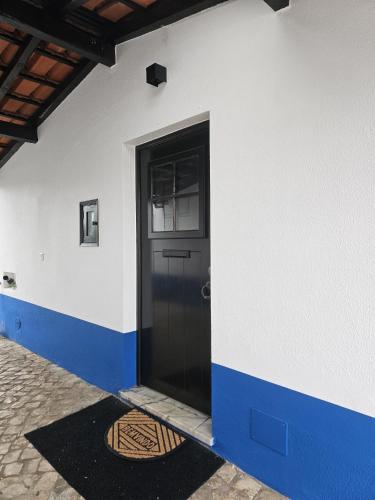a black door on the side of a white building at Sunflower Castle View in Óbidos in Óbidos