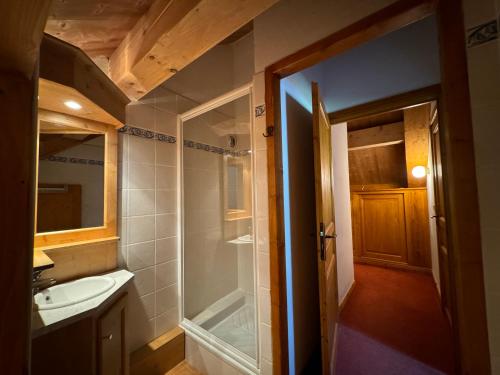 une salle de bain avec une douche, un lavabo et un miroir dans l'établissement Ski in & out spacious apartment, Sauna-Gym-Piscine, à Oz