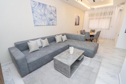 a living room with a gray couch and a table at serenity Stays-Luxury Suites & Appart 8 in Tangier