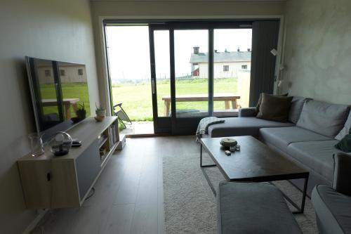 un salon avec un canapé et une table dans l'établissement Lys og moderne leilighet rett ved skiløypa på Nordseter - Kort vei til Sjusjøen, Lillehammer og Hafjell - Dyr ikke tillatt, à Nordseter