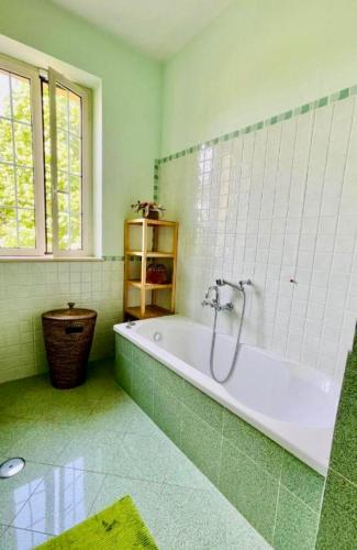 a green bathroom with a tub and a window at Casa Bella Vista in Gubbio