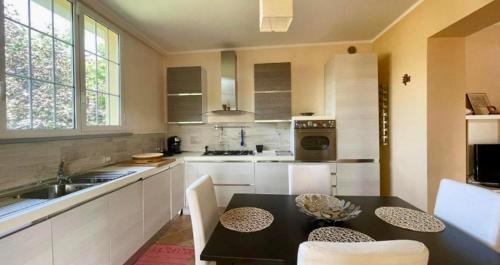 a kitchen with a black table and white cabinets at Casa Bella Vista in Gubbio