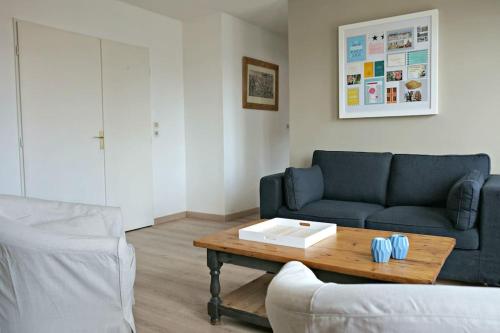 un salon avec un canapé et une table basse dans l'établissement Appartement Vieux Lille avec parking et balcon - Constantine, à Lille