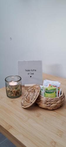 a table with a basket of food and a candle at 't Partijerhöfke in Wittem