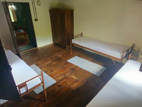 a room with two beds and a wooden floor at Mlýn Horní Hamr in Pavlice