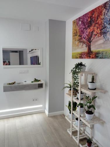 a white room with plants and a painting on the wall at Apartamento Plaza Palmeras in Burjassot