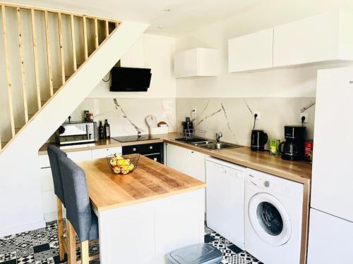 una cocina con fregadero y lavadora en Ferme Cosy et Paisible au Bord de l'Eure, en Criquebeuf-sur-Seine