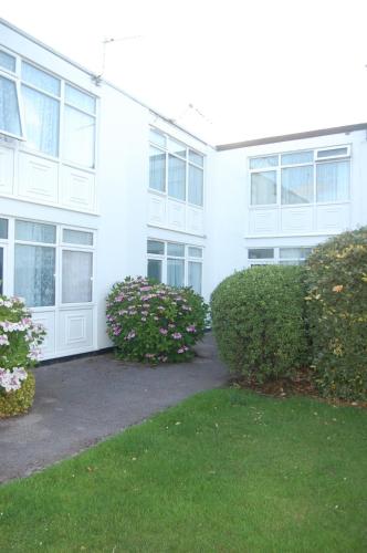 a white building with bushes in front of it at Dawlish Warren Welcome Family Holiday Park Villa Clover Welcome2Warren South Devon in Dawlish Warren