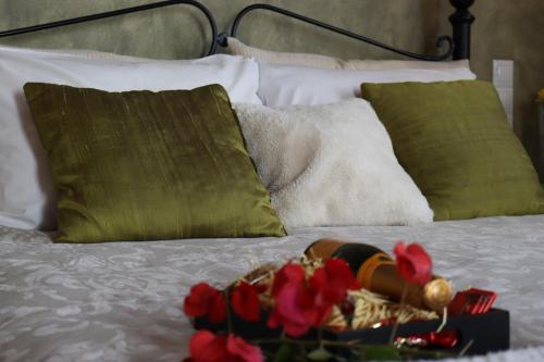 a bed with green pillows and red flowers on it at Valley View House in Anópolis