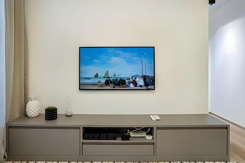 a living room with a tv on a white wall at HomeCO - Conforto na esqui praia in Niterói