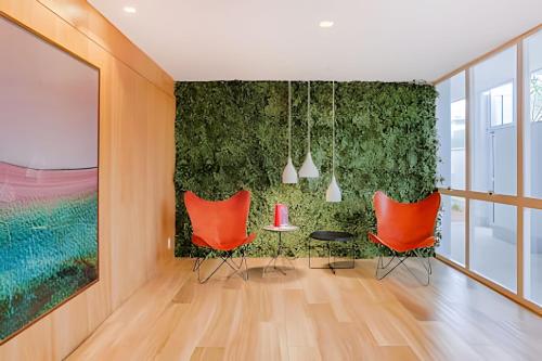 a room with orange chairs and a green wall at HomeCO - Conforto na esqui praia in Niterói