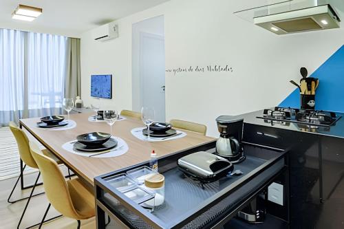 a kitchen with a table with plates and wine glasses at HomeCO - Conforto na esqui praia in Niterói