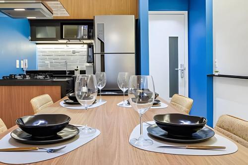 a dining room with a table with wine glasses at HomeCO - Conforto na esqui praia in Niterói