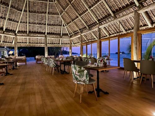 a restaurant with tables and chairs with a view of the ocean at Ocean Boutique Hotel - Adults only in Pingwe
