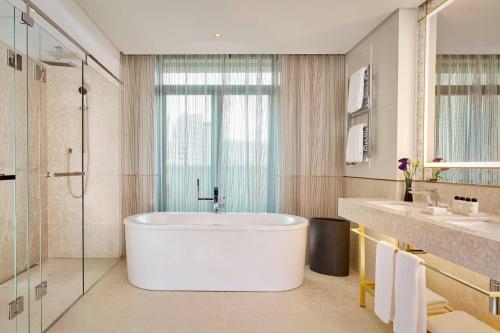 a bathroom with a tub and two sinks and a shower at The Alexander, a Luxury Collection Hotel, Yerevan in Yerevan