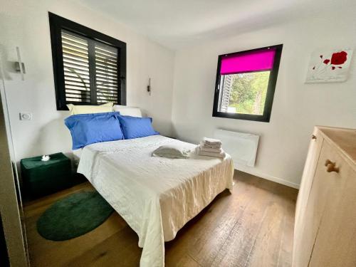 une chambre avec un lit avec des oreillers bleus et une fenêtre dans l'établissement Villa Floralie, à Vidauban