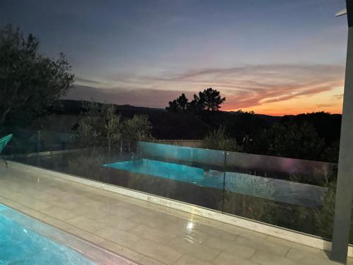 une piscine avec un coucher de soleil en arrière-plan dans l'établissement Villa Floralie, à Vidauban