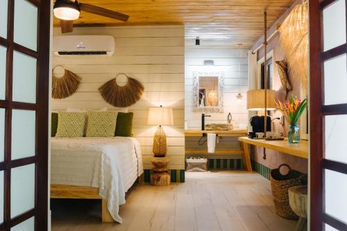 una camera da letto con un letto e un bagno con un lavandino di Tranquilseas Eco Lodge & Dive Center a West End