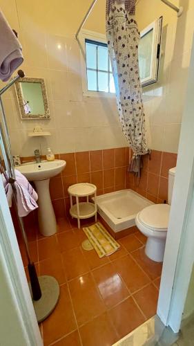 a bathroom with a toilet and a sink and a tub at Little Paradise Livadi Himare in Himare