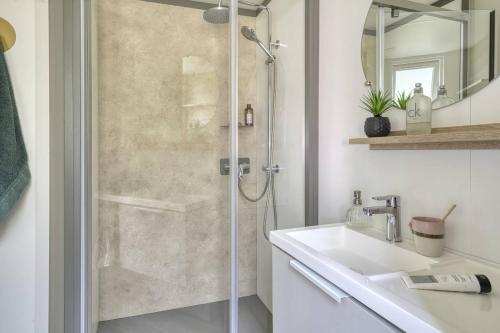 une salle de bain avec une douche avec un lavabo et un miroir dans l'établissement Tahiti Village La Grande Côte, à Saint-Palais-sur-Mer