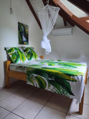 ein Schlafzimmer mit einem Bett mit einer grün-weißen Decke in der Unterkunft Sunshine Villa in Pointe-Noire