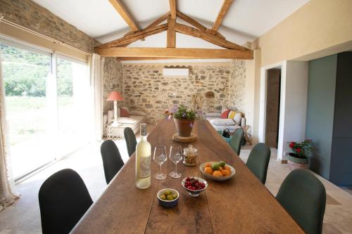 une salle à manger avec une longue table en bois et des chaises dans l'établissement Gîte isolé au cœur du vignoble, à Roquebrun