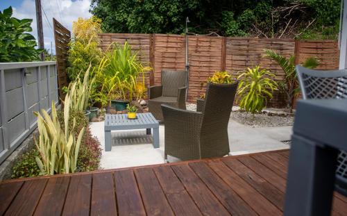 a patio with chairs and a table and a fence at Morning Sun Place Tahaa in Taha’a