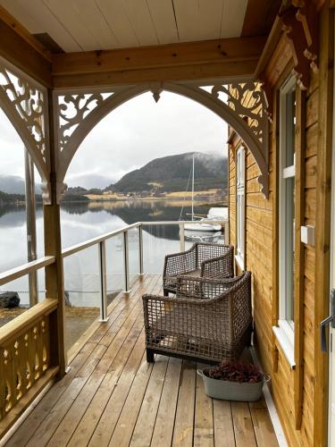 a porch with two chairs and a view of the water at Handelsmannens hus ved Otnesbrygga, Valsøyfjord in Otnes