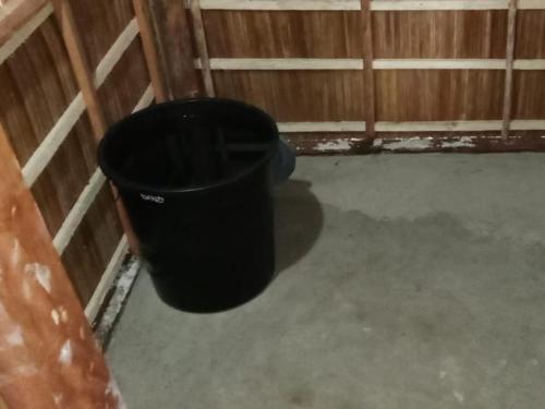 a black trash can in a corner of a barn at Risen Raja Ampat in Pulau Birie