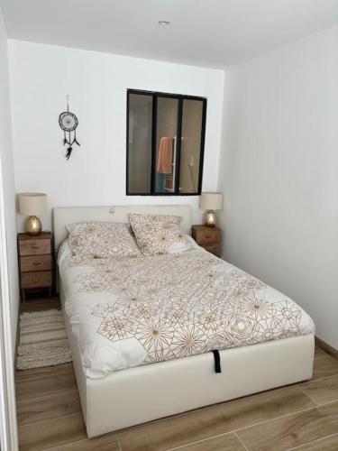 - un lit blanc dans une chambre avec un miroir dans l'établissement Appartement climatisé avec piscine proche mer, au Grau-du-Roi