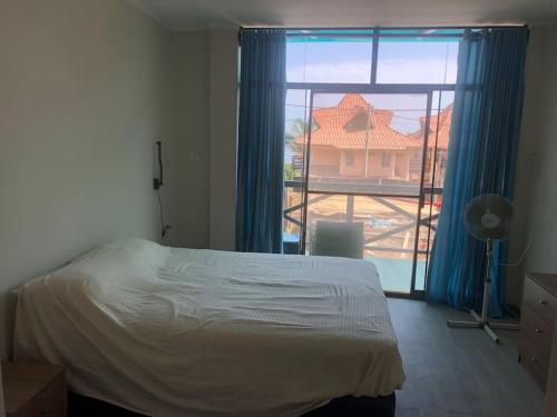a bedroom with a bed and a large window at Nuevo Apartamento en Máncora Las Pocitas in Máncora