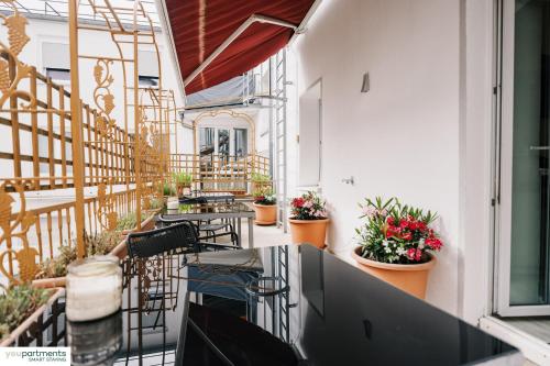 a balcony with tables and chairs and plants at YOUPARTMENTS - zentrale Micro Apartments in Kaiserslautern