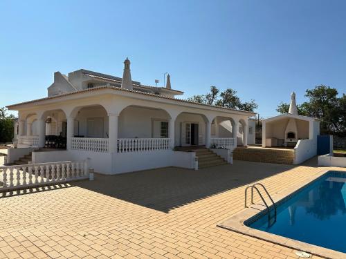 a large white house with a swimming pool at BnB Homes Luxurious Villa Stardust with Swimming pool & BBQ for Family Fun in Ameijoafas