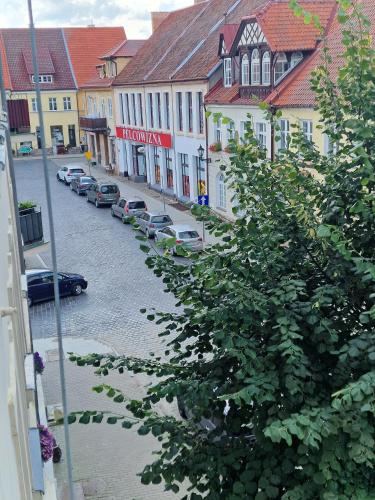 a city street with cars parked on the street at Apartament Rynek in Reszel