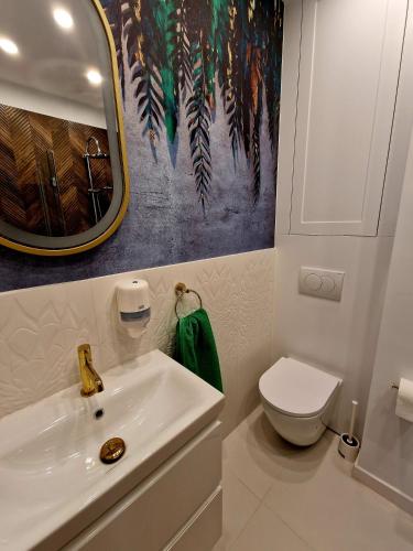 a bathroom with a white sink and a toilet at Apartament Rynek in Reszel