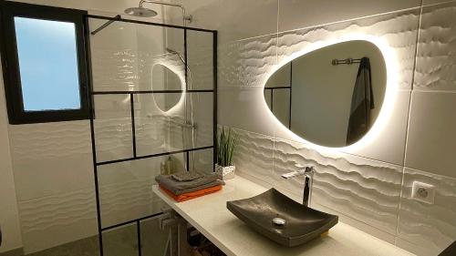 une salle de bain avec un lavabo et un miroir dans l'établissement Maison Parentis en Born, à Parentis-en-Born