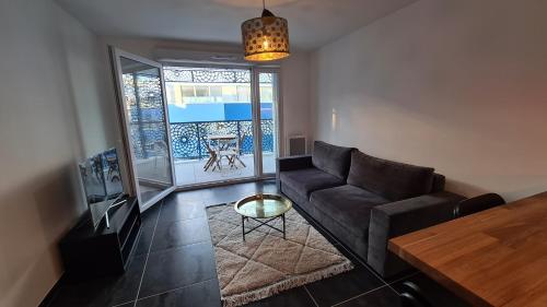 un salon avec un canapé et une table dans l'établissement Appartement Vélodrome Prado Michelet, à Marseille