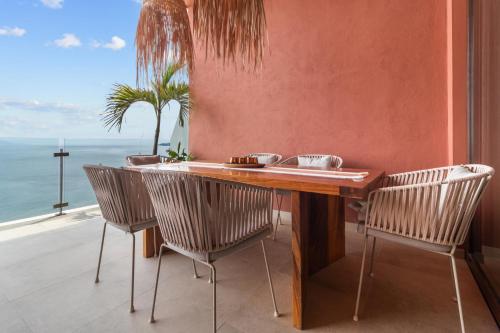 a table and chairs with a view of the ocean at Casa del Mar Bucerias - Beachfront Condos in Bucerías