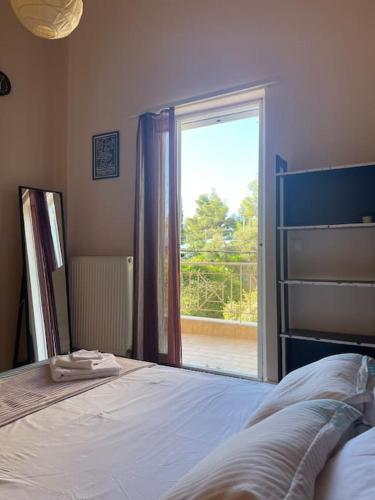 a bedroom with a bed and a sliding glass door at Sea & Serenity - Balcony Daydreaming in Neos Marmaras