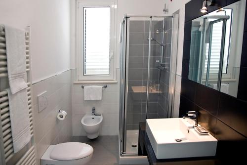 ein Bad mit einem WC, einem Waschbecken und einer Dusche in der Unterkunft Residence Blumare in Martinsicuro