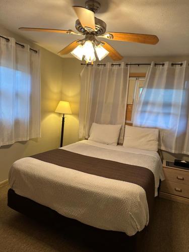 a bedroom with a bed with a ceiling fan at Lakeview Motel & Cottage in Kincardine