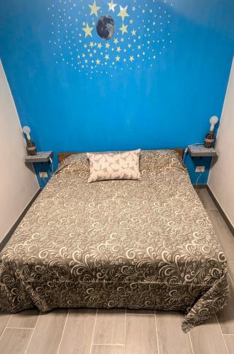 una camera da letto con un letto con una parete blu di Tiny Beautiful Thing Ragusa a Ragusa
