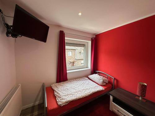 a red bedroom with a bed and a window at Ferienhaus in Duisburg für bis zu 9 Personen - Arbeiten im Ruhrgebiet in Duisburg